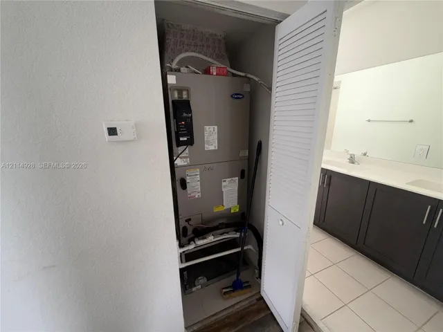 Carrier HVAC system housed in a utility closet with louvered door access
