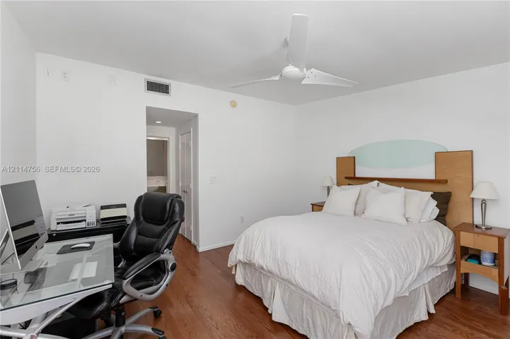 Wood-finish flooring, white walls, and a modern ceiling fan