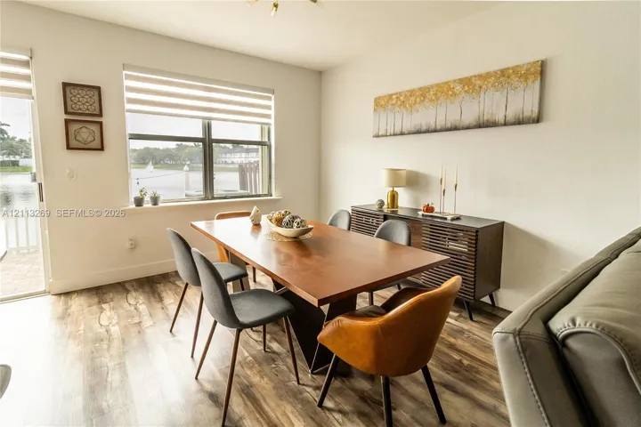 Wood-finish flooring, large window with horizontal blinds, glass sliding door, and neutral wall tones