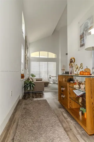 Vaulted ceilings, wood-finish flooring, and an arched transom window