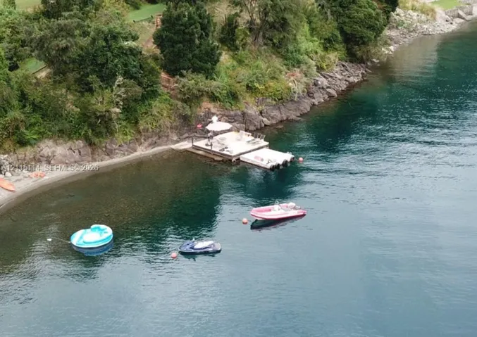 Private waterfront property featuring a multi-level floating dock, stone shoreline, and deep-water access