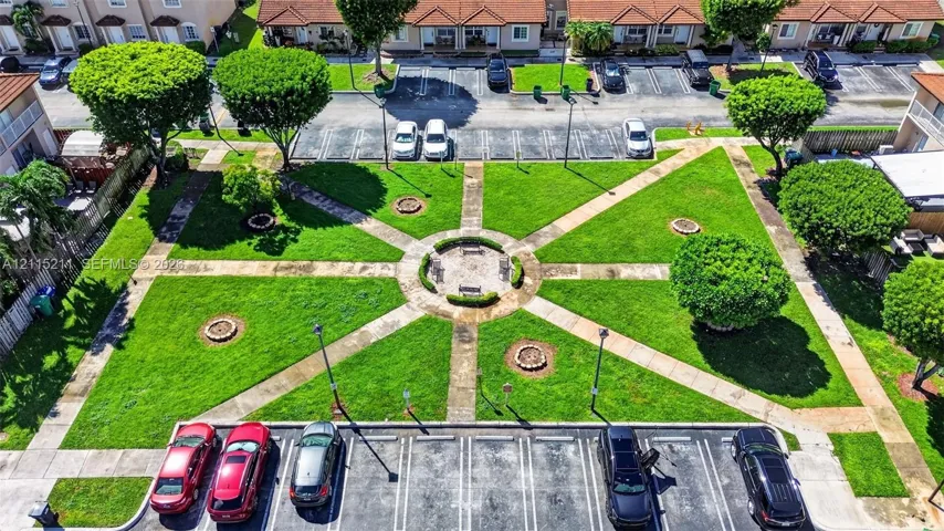 Central courtyard featuring manicured lawn, paved walkways, mature trees, and a circular seating area