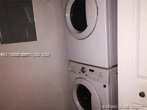 Stacked large white front-loading washer and dryer.