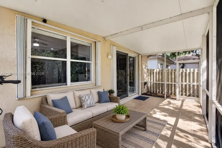 Screened-in patio featuring tile flooring, metal framing, sliding glass doors, and a solid roof covering