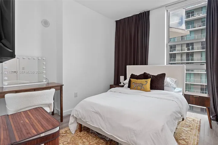 Floor-to-ceiling window featuring natural light, wood-finish flooring, and neutral wall tones