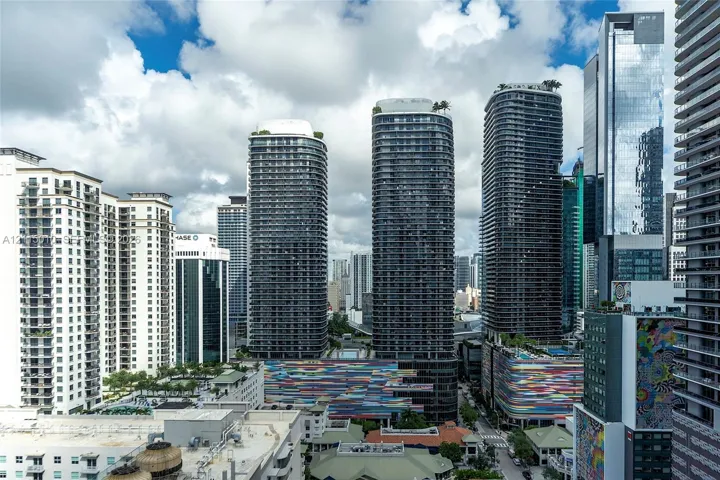 High-rise urban landscape featuring contemporary glass skyscrapers, private balconies, rooftop greenery, and colorful architectural facade accents