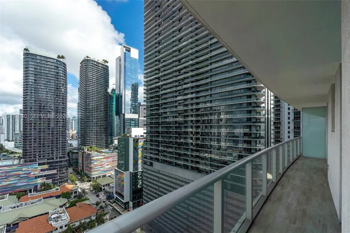 Covered balcony featuring wood-finish flooring and a glass panel railing