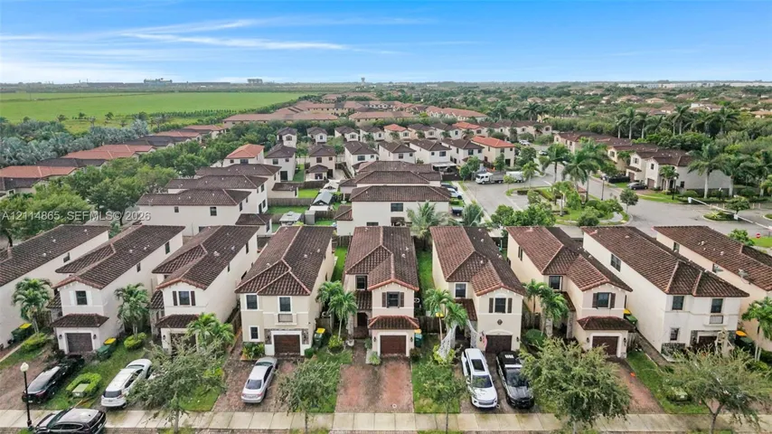 Two-story residential structures featuring tile roofs, stucco exteriors, and attached single-car garages