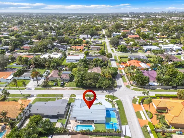 Corner lot property featuring a private swimming pool, multi-use hardscaped sports court, and concrete tile roofing