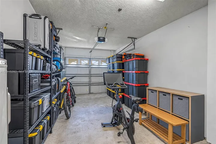 Enclosed garage featuring concrete flooring, a paneled overhead door, and painted walls