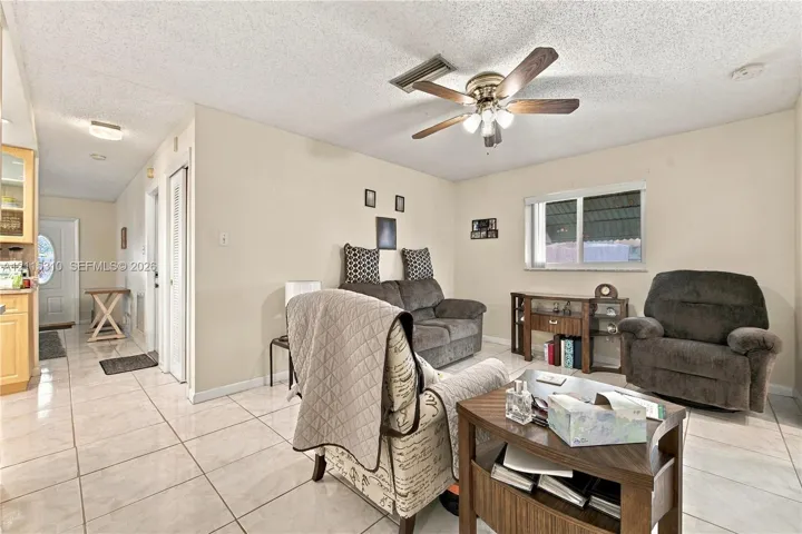 Neutral-toned ceramic tile flooring, ceiling fan with integrated lighting, and horizontal sliding window