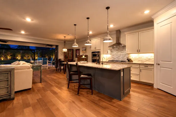 Dinner comes together beneath warm pendant lighting, with the illuminated pool in view and the evening still ahead