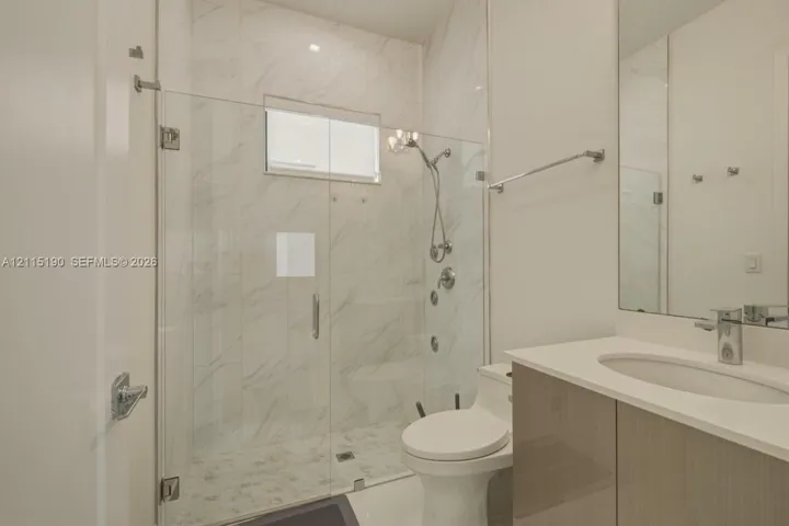 Full bathroom with glass-enclosed shower.