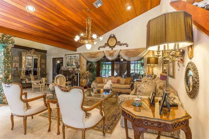 Vaulted wood-plank ceiling featuring recessed lighting and a central multi-arm chandelier