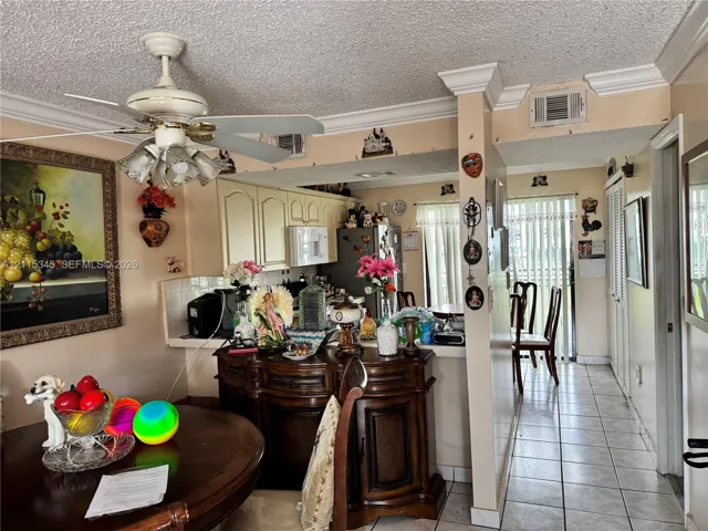 Kitchen featuring light-toned cabinetry, ceramic tile flooring, and crown molding