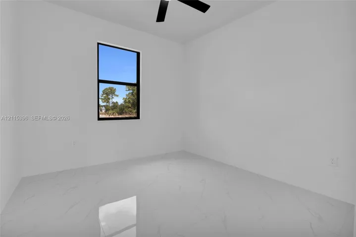 Large-format tile flooring with veining, matte black ceiling fan, and black-trimmed single-pane window