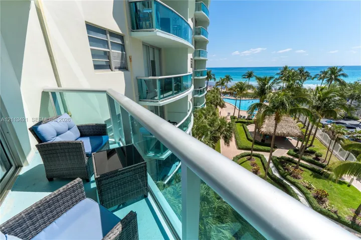 Private balcony with glass panel railing and ocean scenery