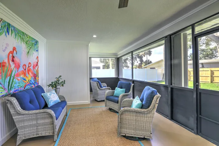 Screened-in porch featuring beadboard wall paneling, a ceiling fan, and large window screens
