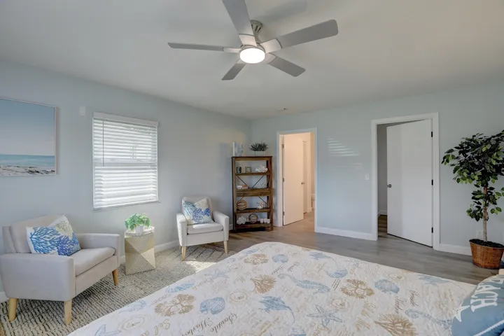 Neutral paint finishes, wood-finish flooring, and ceiling fan with integrated lighting