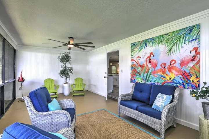Enclosed patio featuring beadboard wall paneling, ceiling fan with integrated lighting, and screen-enclosed walls