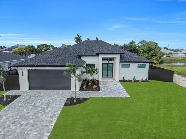 Single-story exterior featuring a hip roof, horizontal siding, paver driveway, walkway, and glass-paneled double entry doors