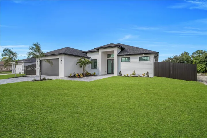 Contemporary exterior featuring stucco and horizontal siding, asphalt shingle roof, two-car garage, and paved driveway