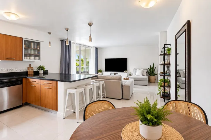 Kitchen featuring wood cabinetry, stone countertops, stainless steel appliances, recessed lighting, and tile flooring