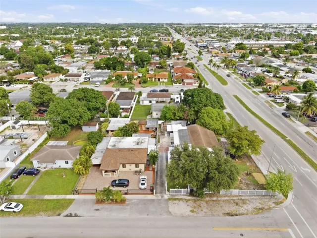 Aerial perspective featuring low-density residential zoning, paved street access, established mature tree canopy, and multi-parcel configuration