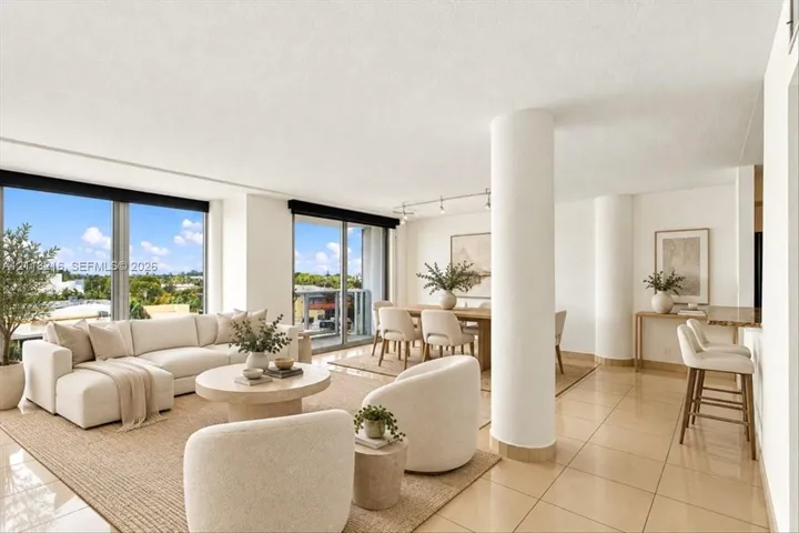 Open-concept floor plan featuring large floor-to-ceiling windows, ceramic tile flooring, architectural structural columns, and recessed track lighting