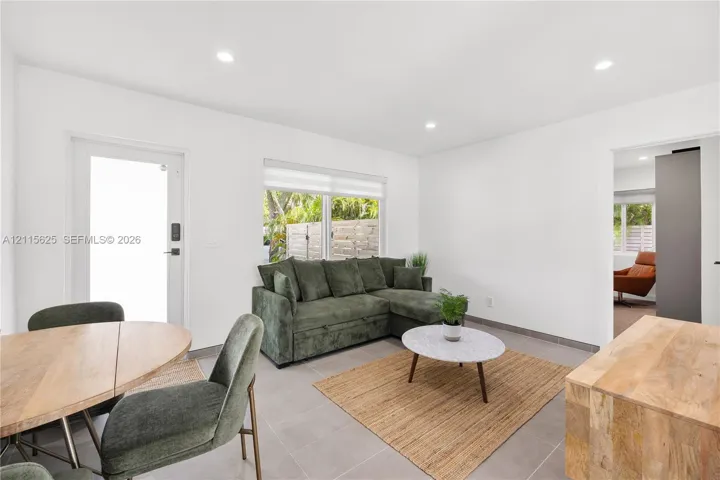 Open-concept room with neutral tile flooring, recessed lighting, and a window with integrated blinds