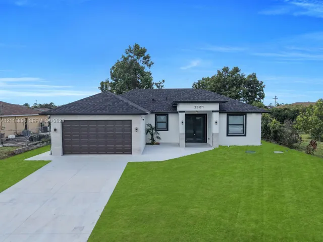 Single-story exterior featuring a light-toned facade, dark-framed windows, a multi-paneled garage door, an expansive lawn, and a paved concrete driveway