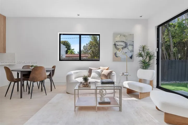 Open-concept living space featuring wood-finish flooring, recessed lighting, and large sliding glass doors providing outdoor access
