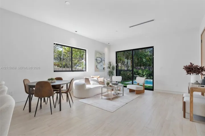 Light-filled living area featuring wood-finish flooring, recessed lighting, and expansive glass sliding doors