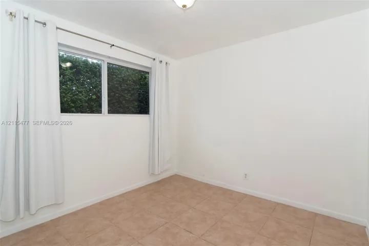 Neutral-toned ceramic tile flooring, clean white wall finishes, and a single-pane horizontal sliding window