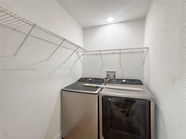 Utility area featuring metal wire shelving and recessed ceiling lighting