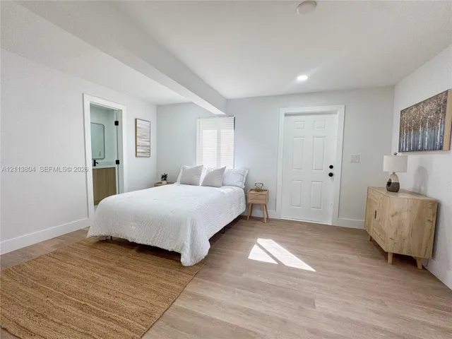 Room featuring wood-finish flooring, a six-panel door, and recessed lighting