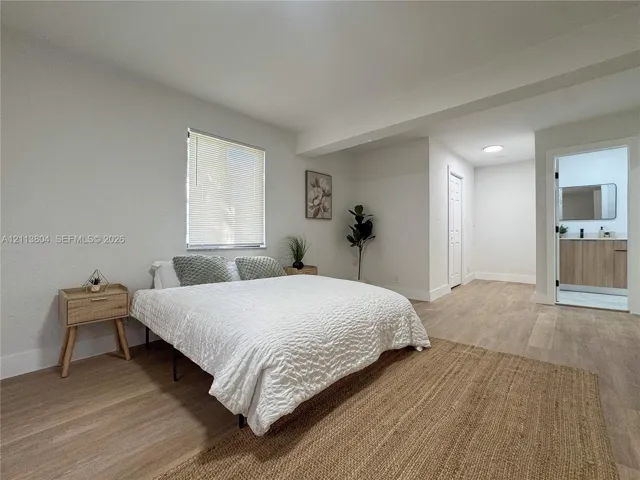 Neutral interior featuring light-tone wood-finish flooring, recessed lighting, and a window with integrated blinds