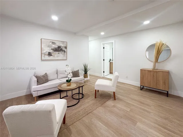 Open-concept space featuring recessed ceiling lighting, neutral walls, and wood-finish flooring