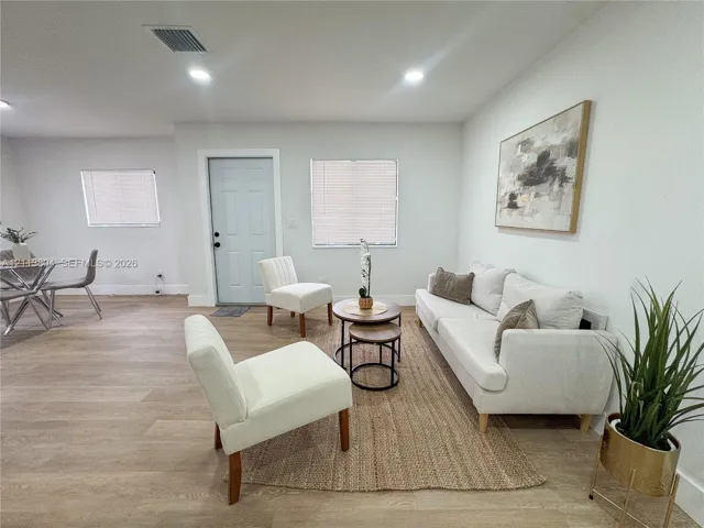 Open-concept interior featuring light-toned wood-finish flooring, recessed lighting, and crisp neutral wall color