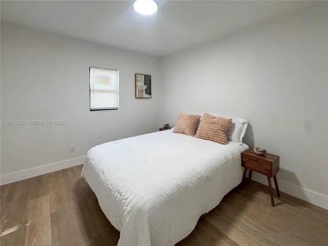 Neutral-toned interior featuring wood-finish flooring, crisp white walls, and a recessed ceiling light