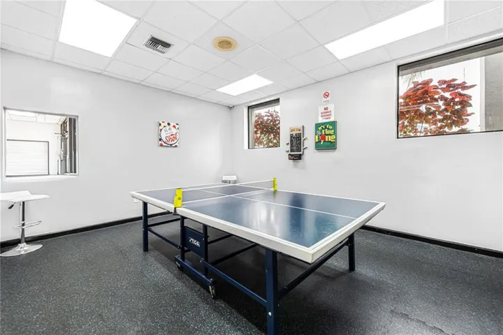 Interior space featuring a drop ceiling with recessed panel lighting, multi-pane windows, and durable rubber flooring