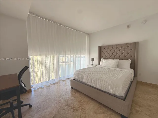 Floor-to-ceiling windows featuring urban scenery and polished stone flooring