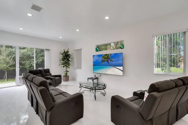 Bright interior space featuring polished tile flooring, recessed lighting, expansive glass sliding doors, and a horizontal clerestory window