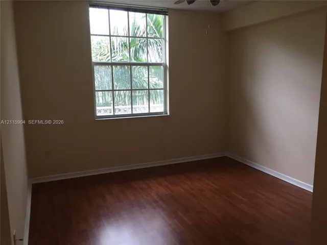 Interior space featuring wood-finish flooring, a multi-pane window, and an attached ceiling fan