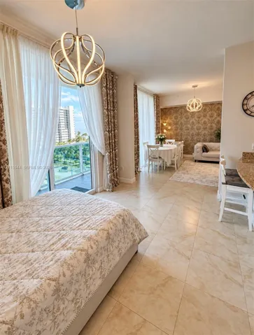 Open-concept space featuring large-format tile flooring, textured wallpaper, two contemporary sculptural pendant light fixtures, and a glass-paneled balcony