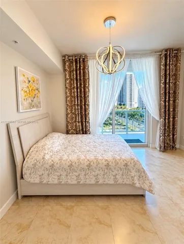 Light-toned tile flooring, contemporary geometric ceiling fixture, and floor-to-ceiling glass panel door opening to a private balcony