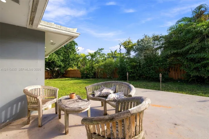 Concrete patio featuring a sodded lawn and perimeter wood fencing