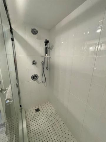 Stand up shower with glass doors.