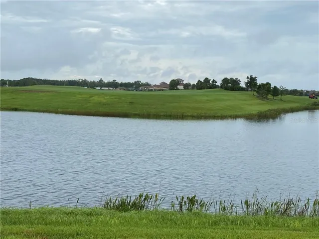 back lanai view with distance lake, golf course and club house view