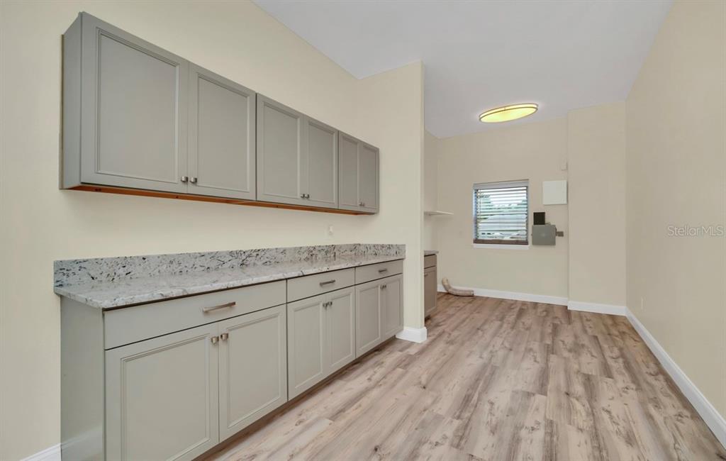 ALL NEW CABINETRY and solid surface countertops in this oversized laundry room